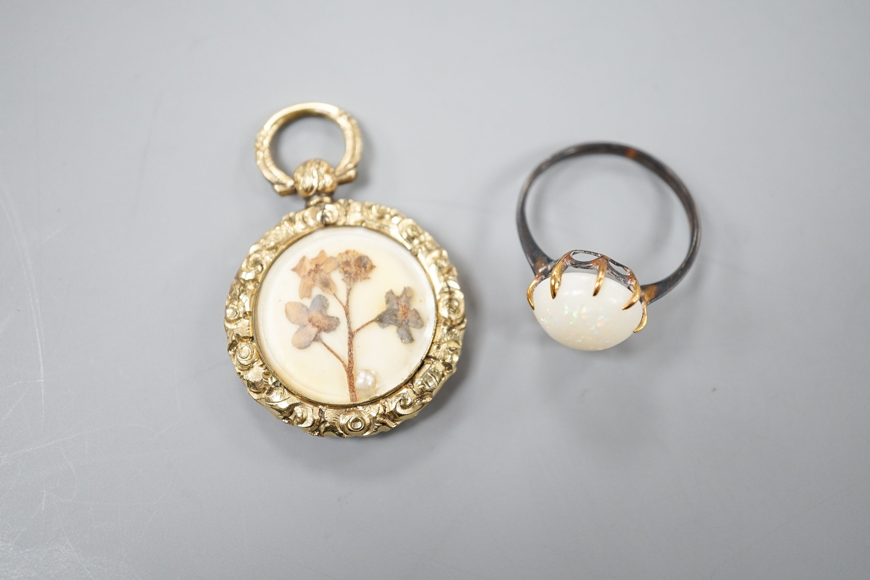 A yellow metal and white opal ring, size K/L and a late Victorian engraved yellow metal pendant, 25mm.